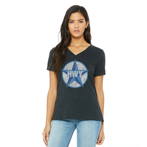 A woman wearing a Charcoal V Neck Relaxed fit T-Shirt with a two toned blue graphic of the Blue Star Highway logo on it.